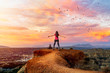 Young woman on top of mountain at sunset