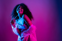 Happy Beautiful Fashion Young African American Girl Hipster Black Woman Hold Stylish Glasses. Wear Raincoat Look At Camera Laughing Dancing Isolated On Disco Party Purple Pink Trendy Studio Background
