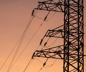 Electric pole with wires on a sunset background