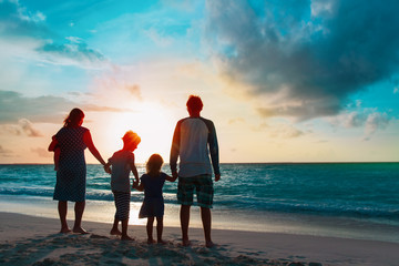 happy family with tree kids walk at sunset beach