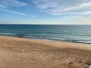 beach and sea with blue sky and orange sand