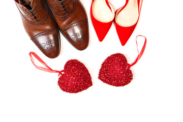 Valentines day concept with man and woman shoes with two red hearts on white background, isolated.