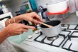 © MDBPIXS - Cropped image of senior woman cooking at kitchen counter