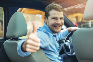 man sitting inside the car and showing thumb up gesture