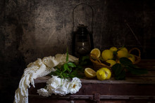 Still Life With Roses On A Old Box And Lemons Close-up.