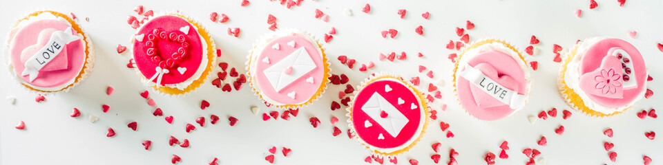 Valentine's day greeting card. Sweet Valentine's creative dessert food. Homemade pink and red  delicious cupcakes with decor of Valentine day symbols