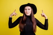 © pantovich - Beautiful girl in black hat wearing glasses for vision showing thumbs up