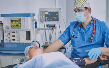 Several doctors surrounding patient on operation table during t