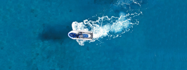 Wall Mural - Aerial drone ultra wide top view photo of jet ski water craft cruising in deep blue Mediterranean sea