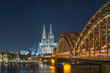 Illuminated Cologne Cathedral and Hohenzollern Bridge at night 
