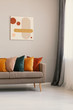 © Photographee.eu - Abstract painting on beige wall above brown sofa with colorful pillows