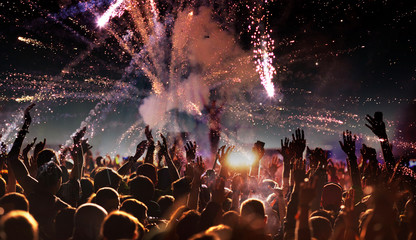 crowd with raised hands at concert festival banner