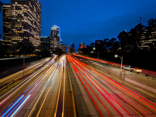 Wall Mural - JANUARY 20, 2019, LOS ANGELES, CA, USA - California 110 South leads to downtown Los Angeles with streaked car lights at sunset