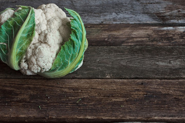 Wall Mural - Fresh farmer cauliflower head on old rough wooden surface, healthy eating concept, selective focus