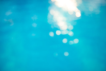 Wall Mural - Bokeh light effects over a rippled, blue water background