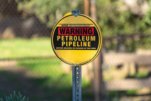 Petroleum Pipeline Warning Sign With Chain Link Fence And In Background.