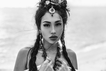 close up portrait of oriental stylish boho girl on the beach at sunset. black and white portrait