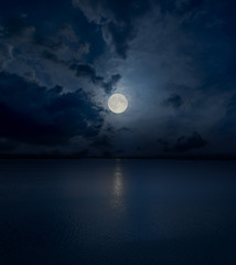 Wall Mural - full moon in clouds over water