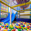 Children playground indoor. Nice plastic gym for activity in playroom. Inside the plastic dry pool with colorful balls and slide.