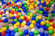 Balls in playground for colorful background. Dry plastic pool with many small balls for play. Pattern with plastic color balls in kids playroom.