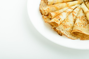 Russian style pancakes on a white plate studio shot