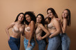 © New Africa - Group of women with different body types in jeans and underwear on beige background