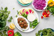 Fresh Homemade Falafels Served With Tahini Sauce, Herbs And Vegetables, Top Down View