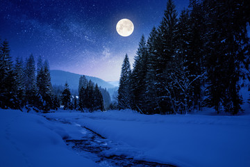 Wall Mural - frozen and snow covered mountain river at night. carpathian winter landscape in full moon light ligh