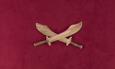 Wall Mural - wooden sword isolated on red background