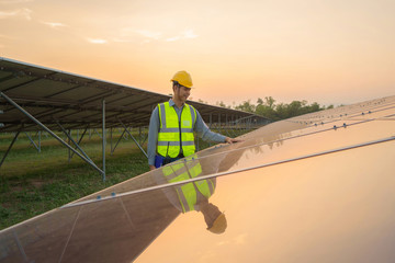 Portrait of engineer man or worker, people, with solar panels or solar cells on the roof in farm. Power plant with green field, renewable energy source in Thailand. Eco technology for electric power.