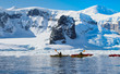 Kajak fahren in der Antarktis mit Eisberge im Hintergrund