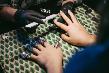 Woman in a nail salon receiving a manicure by a beautician