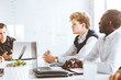 © xartproduction - A team of young businessmen working and communicating together in an office. Corporate businessteam and manager in a meeting.