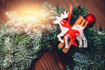 Top view florist making Christmas wreath on wooden table, flat lay tree branches secateurs, deer with red scarf