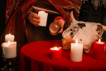 A woman holds a candle to perform magical rituals. The witch casts a spell. The concept of magic and witchcraft