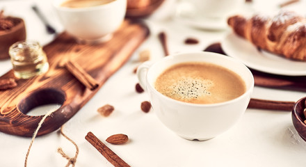 Breakfast with coffee and croissants on wooden table,