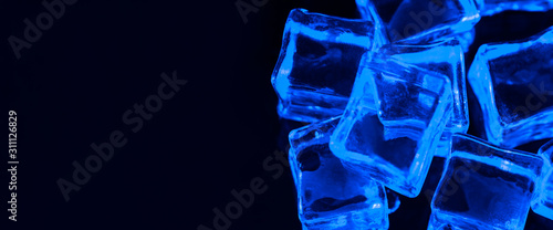 banner-ice-cubes-on-black-background-with-blue-backlight-illuminated-ice-cubes-left-empty-space-under-the-inscription