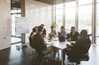 © xartproduction - A team of young businessmen working and communicating together in an office. Corporate businessteam and manager in a meeting.