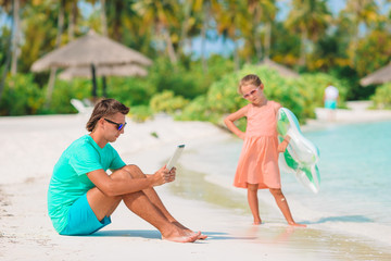 Little girl and happy dad having fun during beach vacation