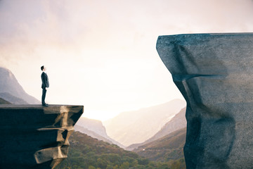 Businessman in suit standing on mountain.