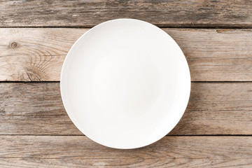 Wall Mural - Empty white dish on rustic wooden table. Top view