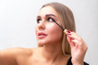 © Евгения Медведева - Beauty portrait of girl with perfect nude make-up. Painting eyelashes with mascara. Turned aside. Beauty salon. Head and shoulders, studio, indoors.