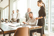 © xartproduction - A team of young businessmen working and communicating together in an office. Corporate businessteam and manager in a meeting.