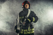 © alfa27 - brave extinguisher or fireman dressed in dark protective suit uniform, with helmet on head, using ropes, hammer and other special equipment at work