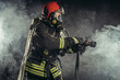 © alfa27 - fireman or firefighter stand in smoke, professional worker of fire station in uniform, in helmet