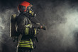 © alfa27 - young firefighter in uniform stand in smoky background wearing uniform, safety concept