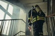 © alfa27 - young extinguisher with hammer go to save and protect wearing uniform, on the landing