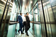 © xartproduction - Business team group going on elevator. Business people in a large glass elevator in a modern office. Corporate businessteam and manager in a meeting.