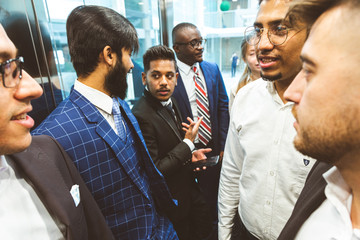 Sticker - Business team group going on elevator. Business people in a large glass elevator in a modern office. Corporate businessteam and manager in a meeting.