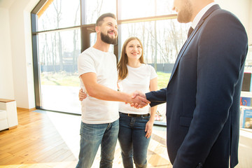 Wall Mural - real estate agent shows a young couple a new home. family buys housing